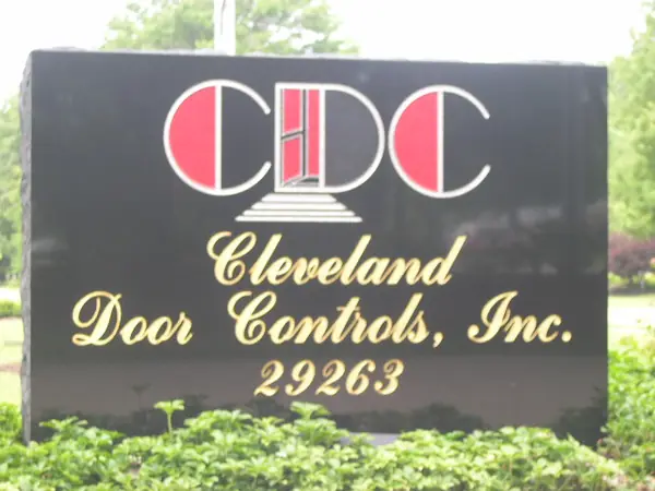 A polished black granite business sign with a company logo in colour, the name in gilt script and the street number below