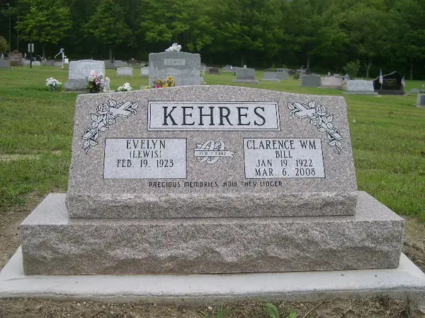 A rose granite slant marker with carved doves and banners at both corners, two name tablets, an anniversary emblem and an epitaph across the foot