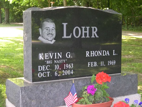 A polished black granite upright monument with a laser-etched portrait beside the name, two name tablets and a nickname in quotation marks